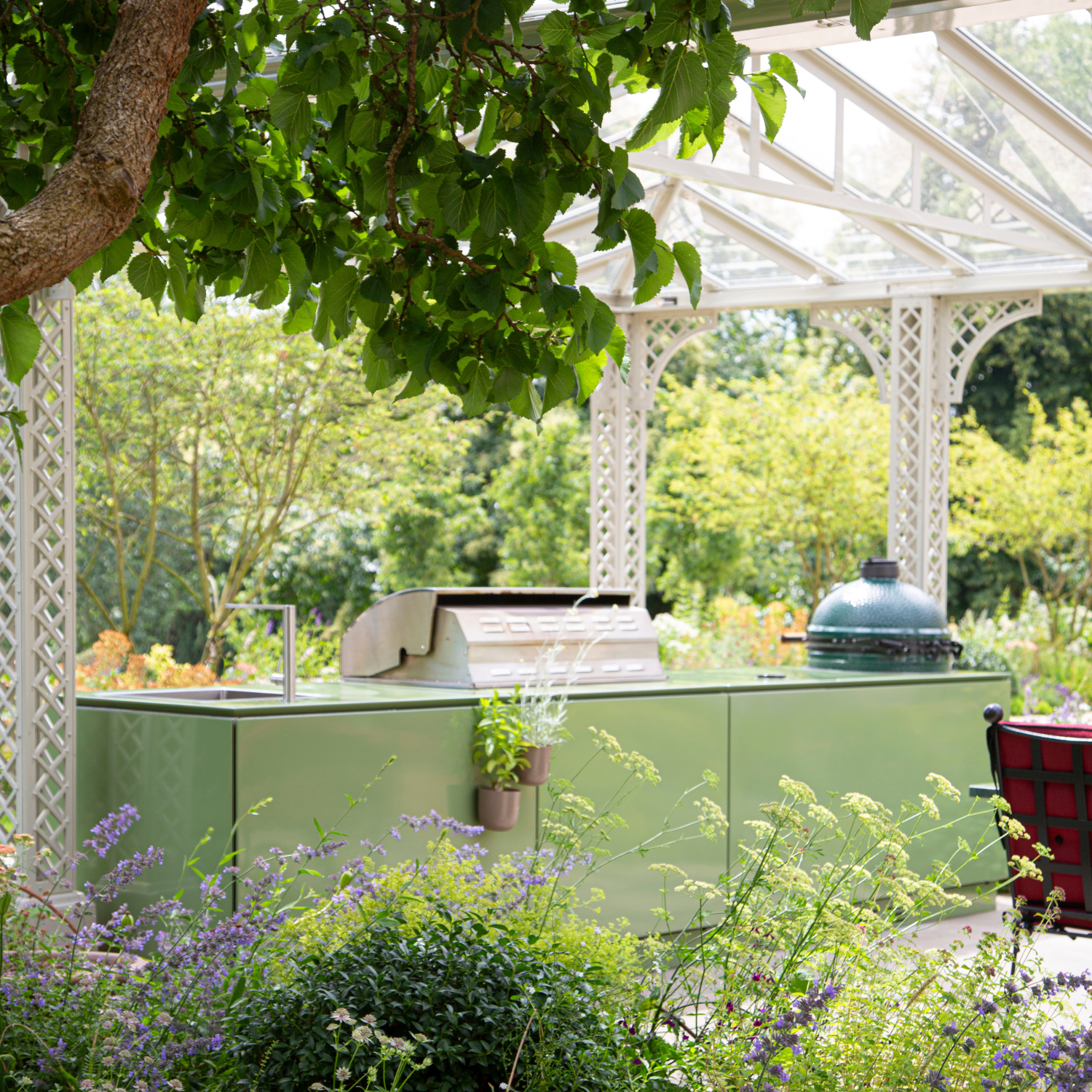 The beautiful green Vlaze outdoor kitchen incorporates a BBQ grill, sink, fridge and ceramic oven